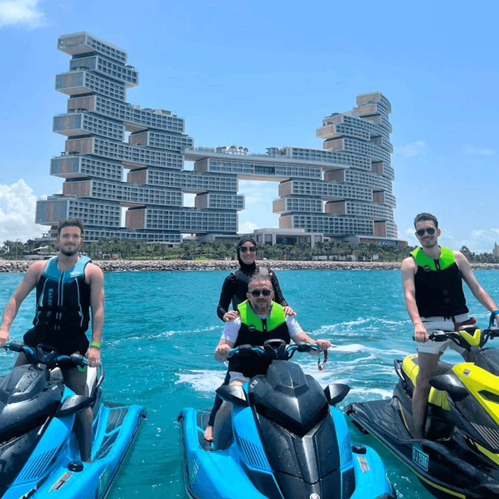 Jet ski riders posing near Atlantis The Royal, with Atlantis The Palm in the distance.