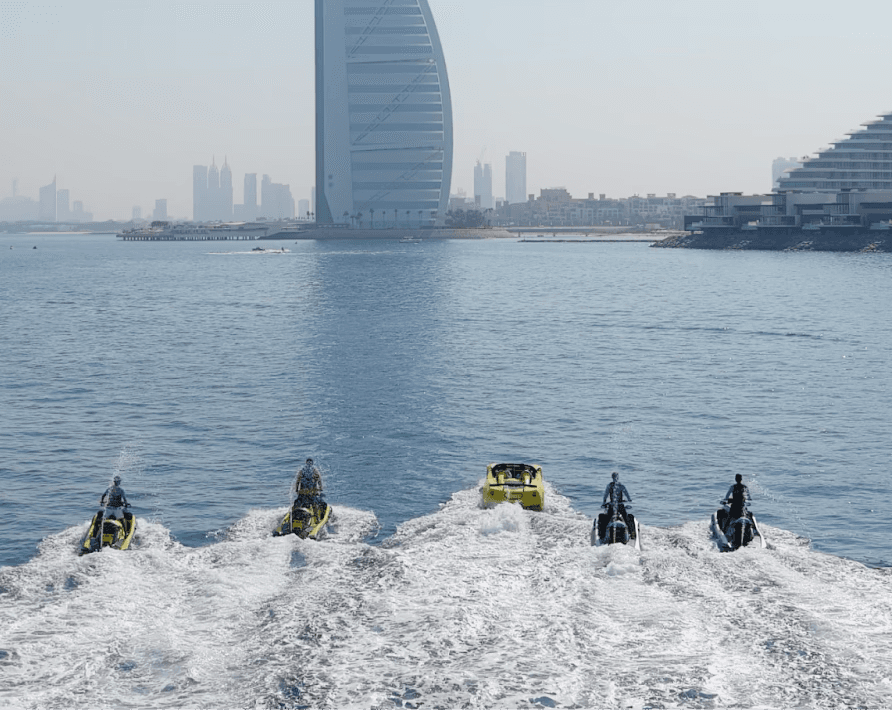 Group riding jet skis and a jet car near Burj Al Arab in Dubai during watersport activities