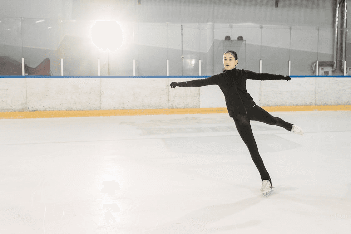 A young girl figure skating in an indoor rink, one of the top indoor family activities in Dubai.
