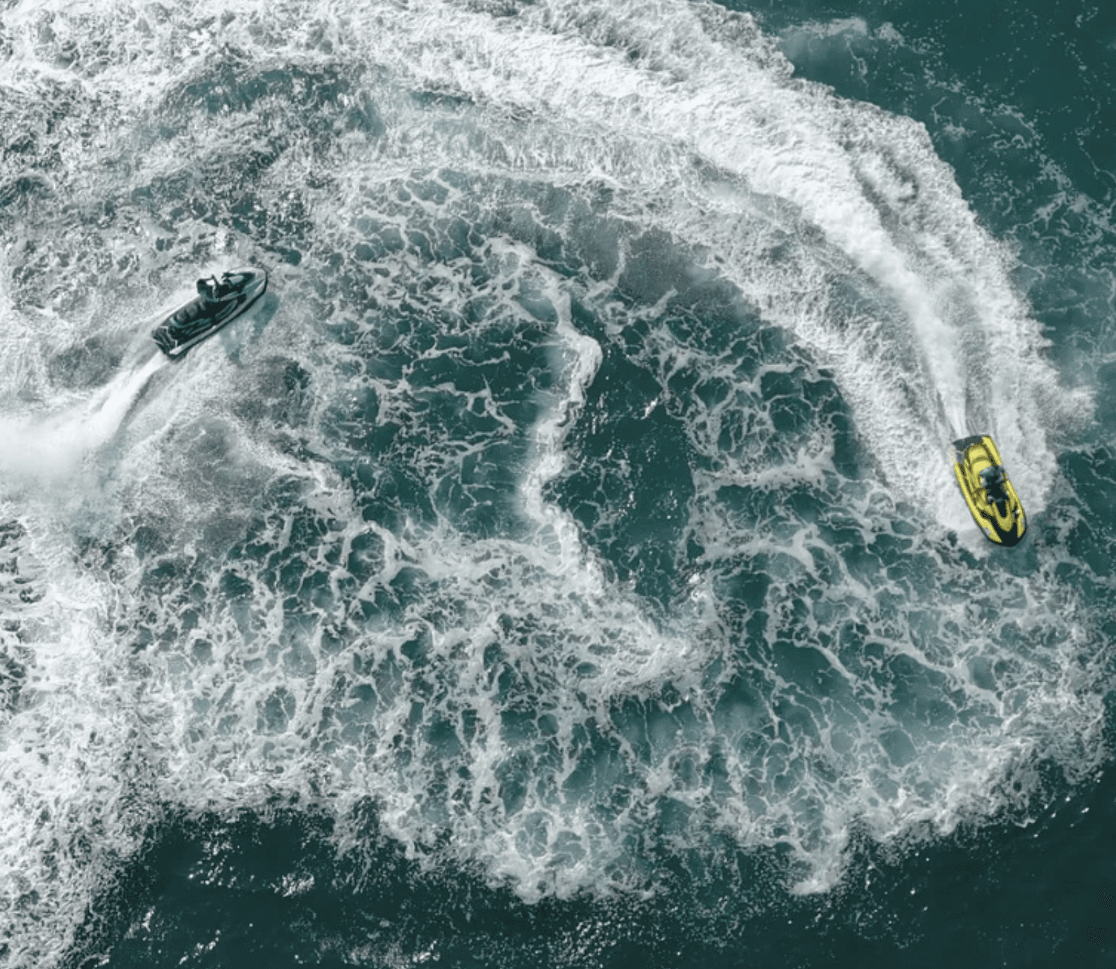 Jet ski water sports in Dubai captured from above, showing two jet skis creating circular patterns, a must-see thrill on your packing checklist for fun beach water sports.