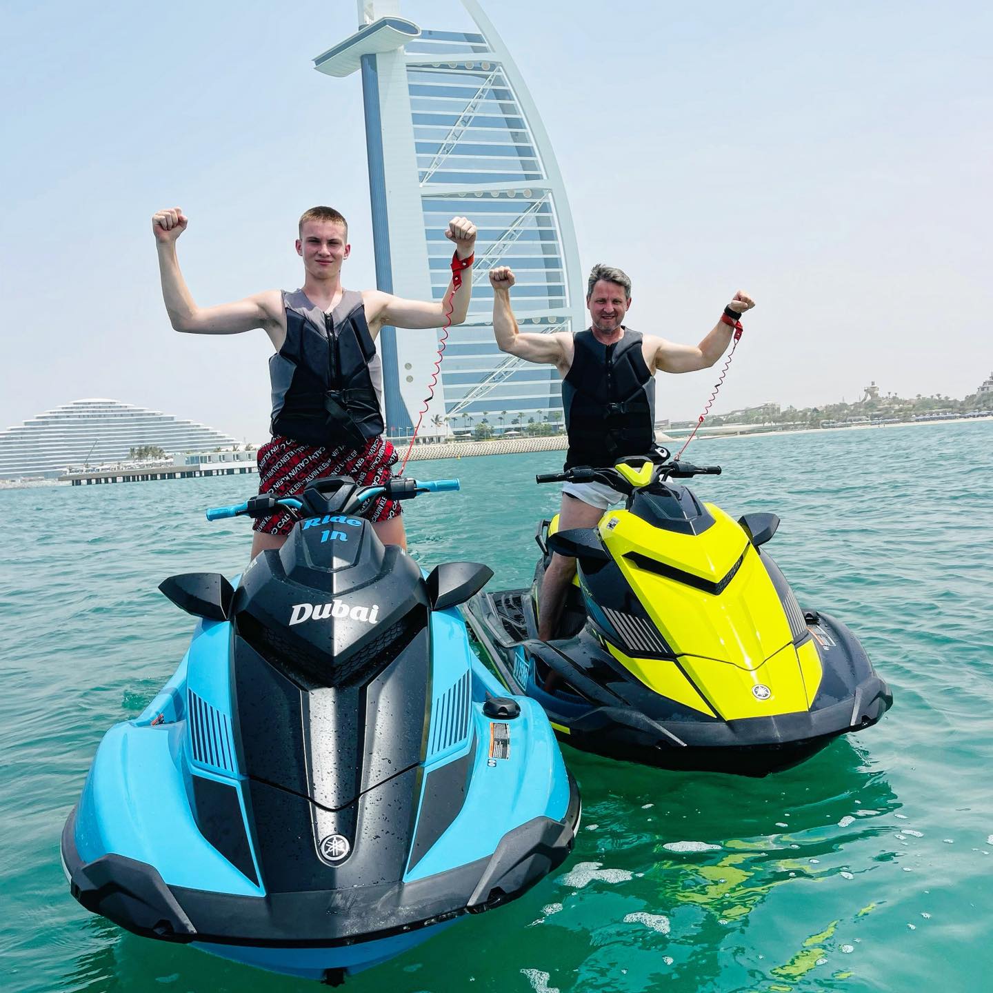 Two men posing on jet skis in front of Burj Al Arab during a Ride in Dubai jet ski tour