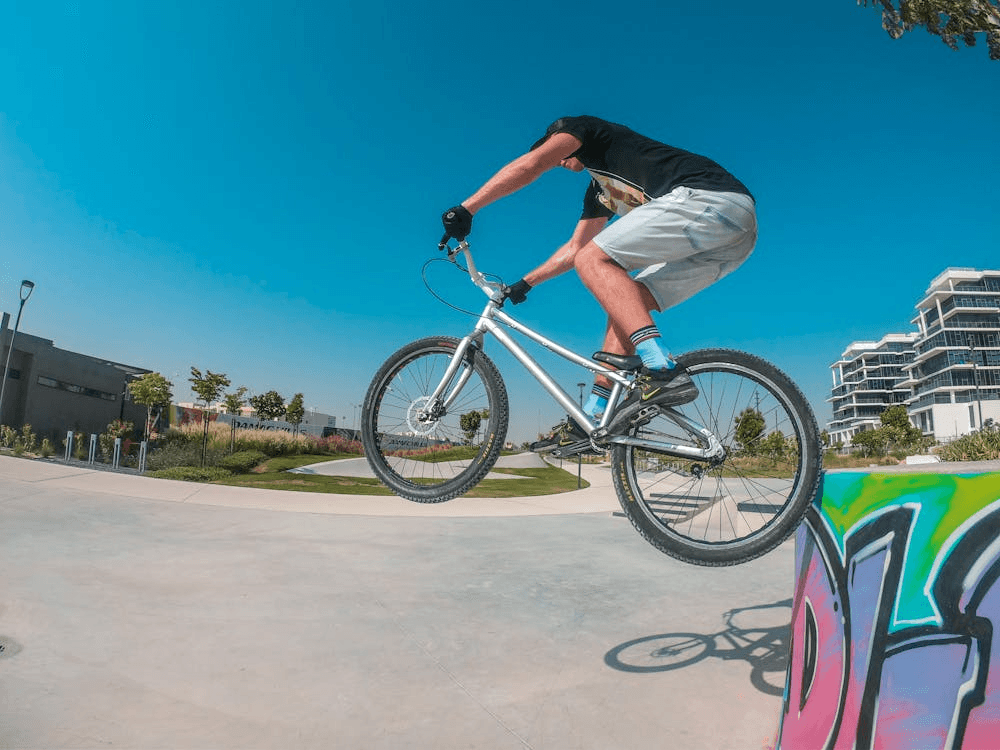 A person performing a stunt on a BMX bike at an outdoor park in Dubai, ideal for energetic family fun.