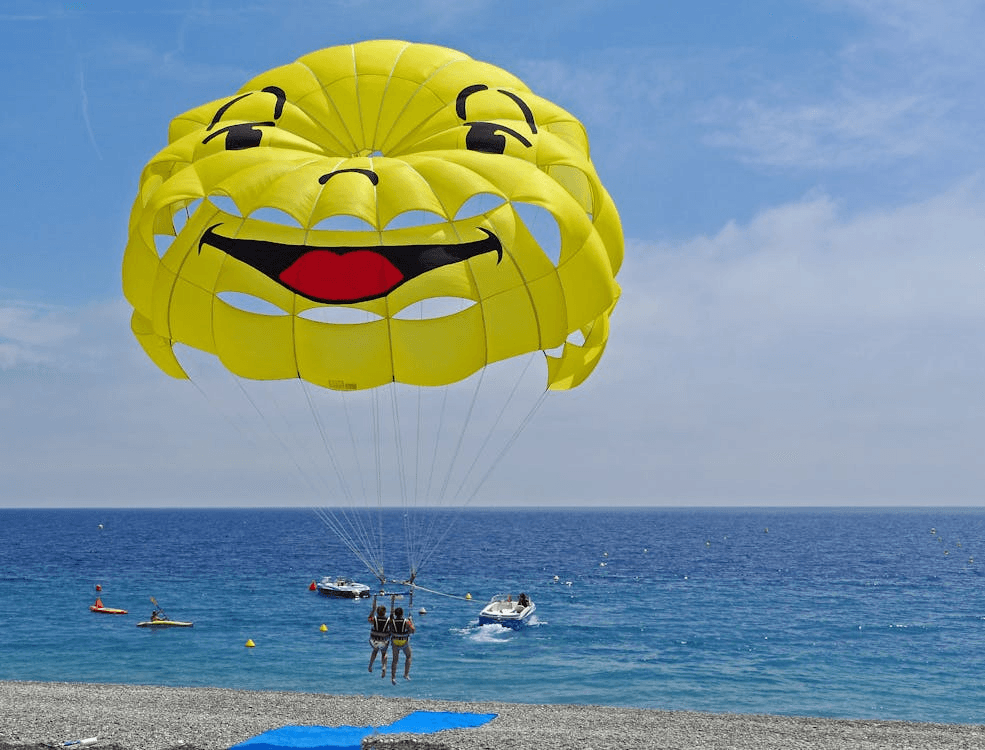 Two people parasailing over the sea, a popular water sport in Dubai for enjoying aerial views