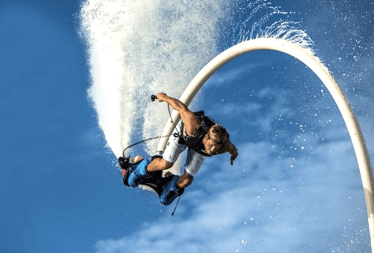 Man flyboarding over the water against a clear blue sky in Dubai, one of the most thrilling family activities in Dubai and a standout among fun activities in Dubai for families.
